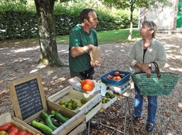 La Borne. Marché du samedi matin. Pascal Baudens et une cliente parlent tomates.