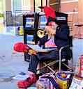 Un clown musicien au coin d'une rue.