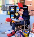 Un clown musicien au coin d'une rue.